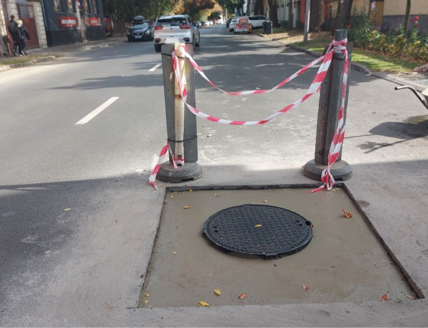 Közműfedlap szintbe helyezését végzik a szakemberek a Bocskai utcában