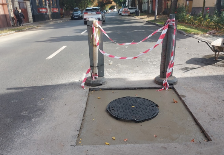 Közműfedlap szintbe helyezését végzik a szakemberek a Bocskai utcában